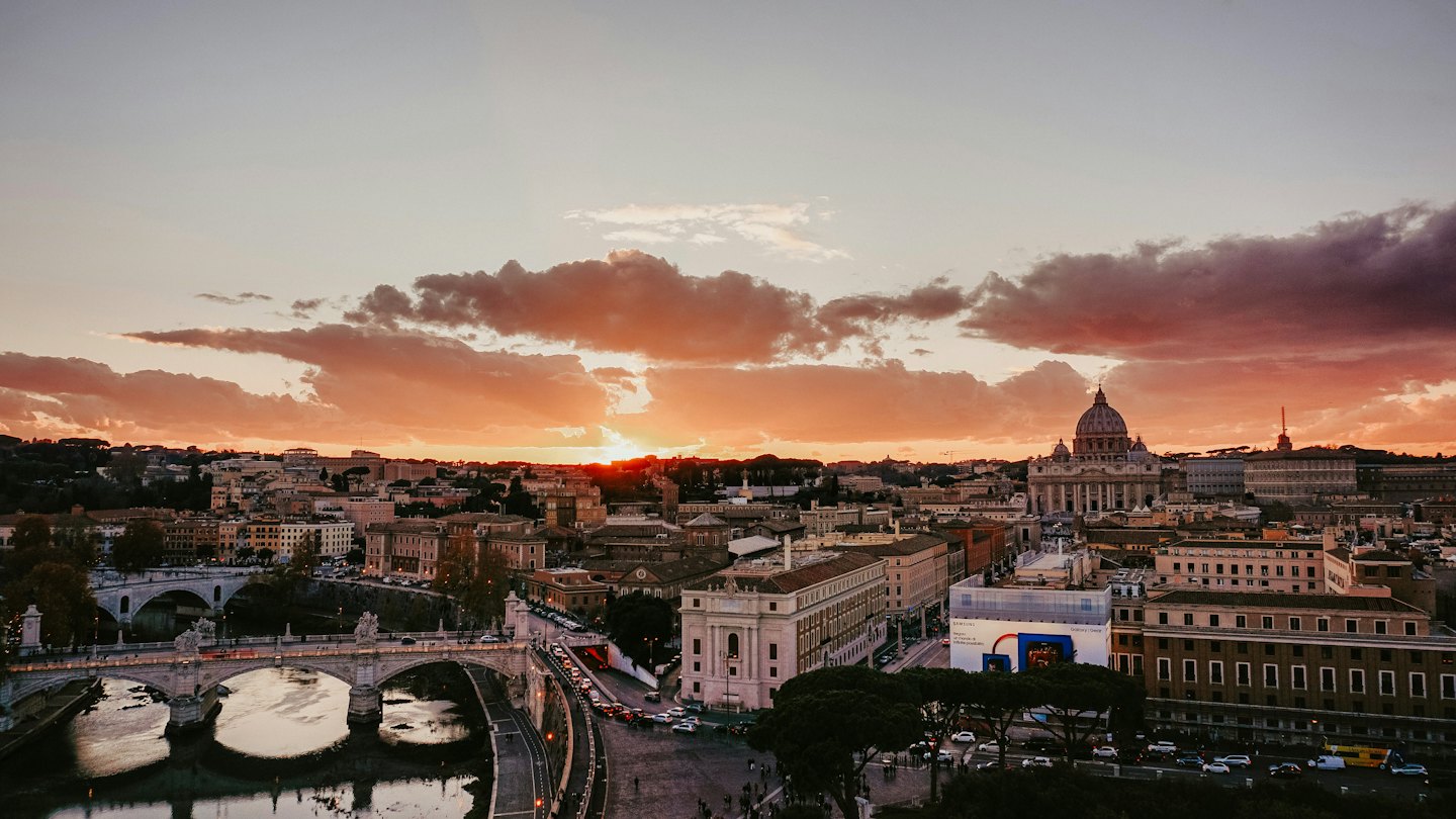 Storico skyline cittadino con una basilica a cupola e ponti in pietra.